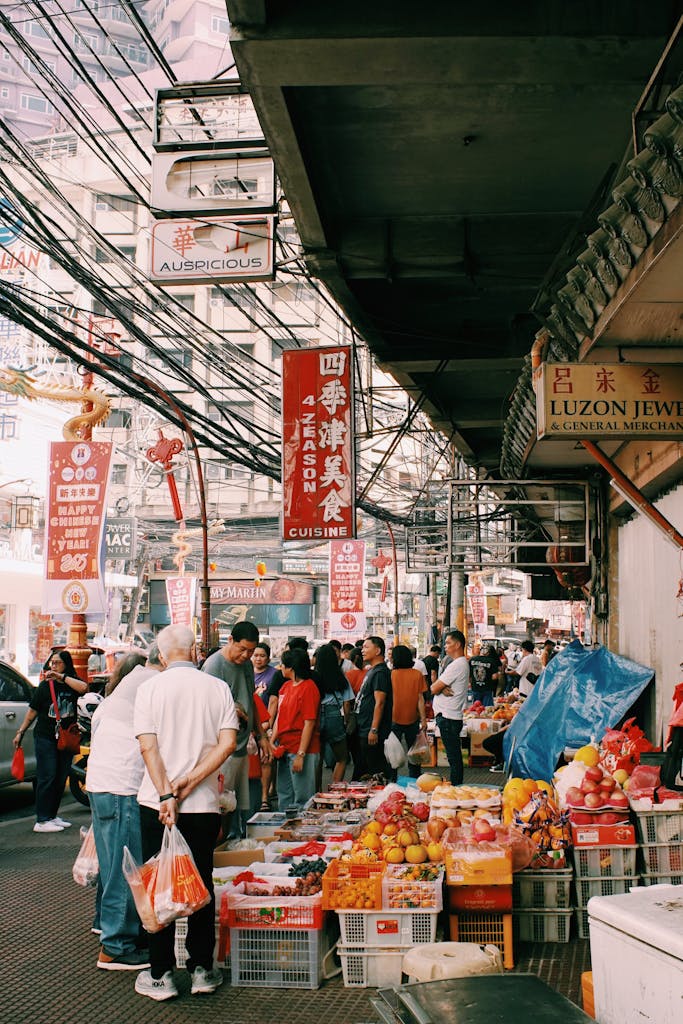 A vibrant street market scene with diverse shoppers and colorful stalls in a busy city.