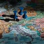 Detailed close-up of a European map with blue pushpins marking important locations.